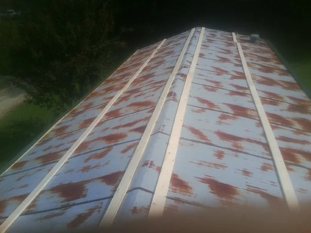 Rusted metal roof panels with new wood purlins before replacement — Storm Damage Roof Repair in Kuna by Roofing Brothers