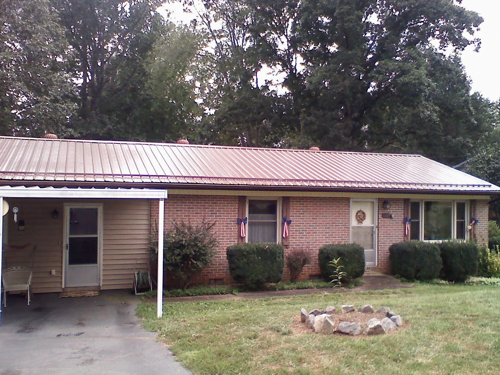 Bronze metal roof and carport on a brick ranch home — Roof Repair work by our crew in Kuna